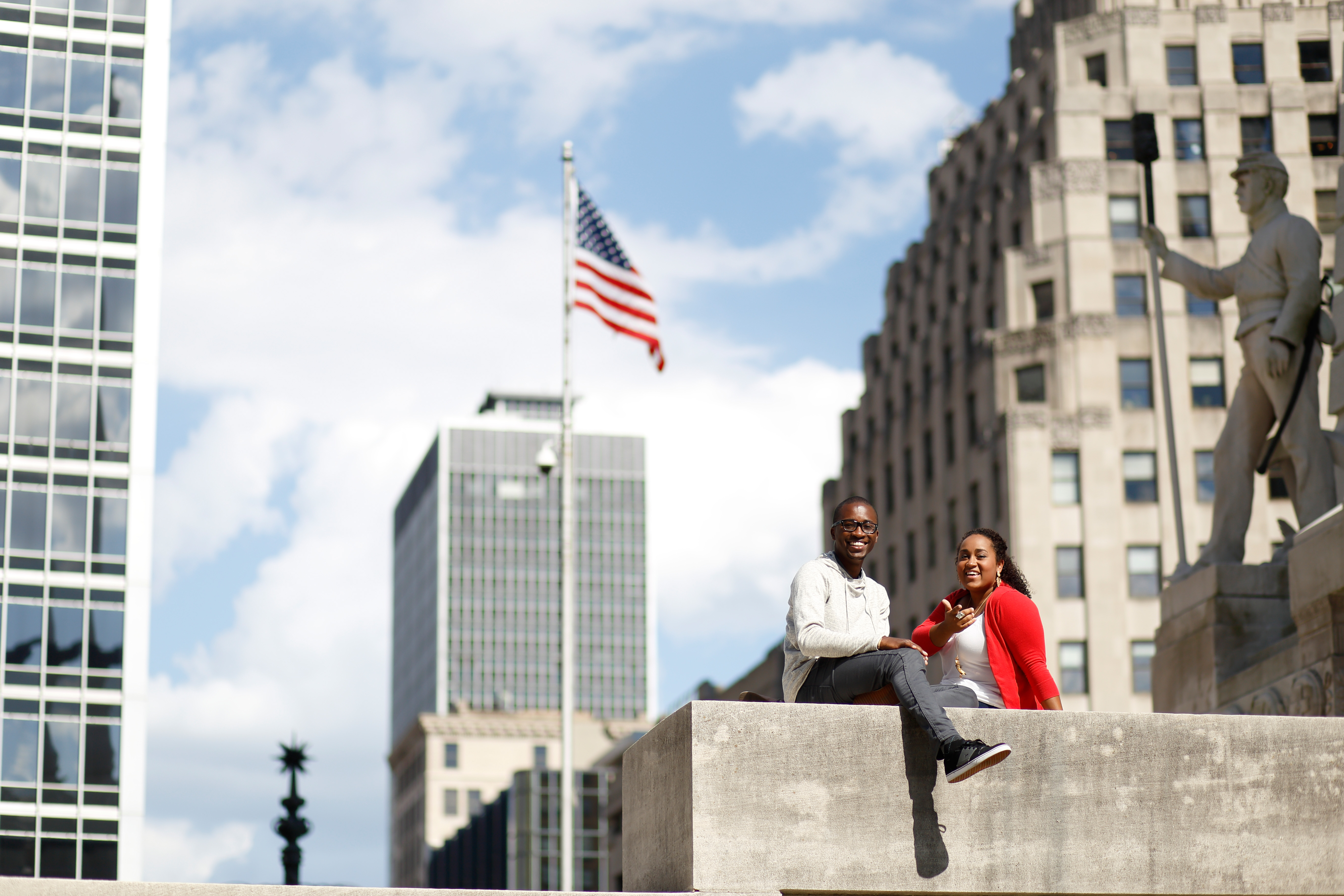 two students siting on the steps of a downtown monument